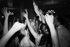 a group of people standing around each other with their hands in the air