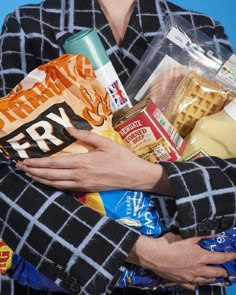 a woman holding food and snacks in her hands