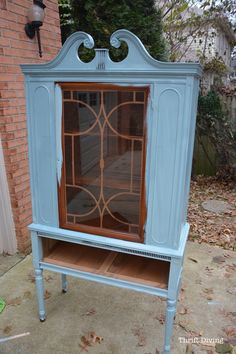 an old china cabinet is painted blue and has glass doors on the front, and sides