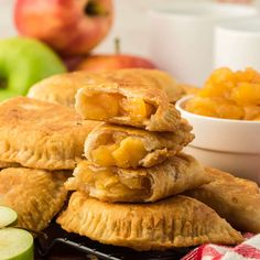 apple pies stacked on top of each other with apples in the background