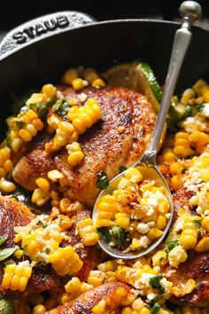 a skillet filled with chicken, corn and feta cheese on top of it