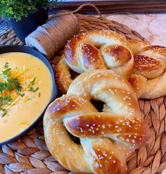 some pretzels are sitting on a wicker basket next to a bowl of dip