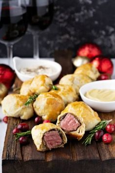 some food is laying out on a cutting board next to wine glasses and other foods