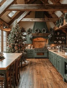 a kitchen with green cabinets and christmas trees on the counter top, along with wooden floors