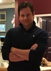 a man standing with his arms crossed in a kitchen