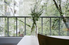 a vase filled with flowers sitting on top of a white table next to a window