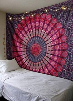 a bed with a colorful tapestry hanging over it