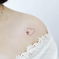 a woman with a small heart tattoo on her shoulder