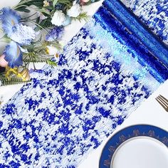 a blue and white table setting with flowers