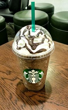 a starbucks drink sitting on top of a wooden table