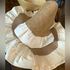 two hats sitting on top of each other in front of a wooden table with chairs