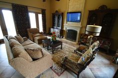 a living room filled with furniture and a flat screen tv mounted on the wall above a fireplace