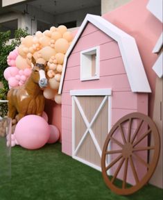 there is a fake horse next to a pink barn with balloons in the shape of animals