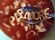 a spoon filled with macaroni and cheese on top of a bowl