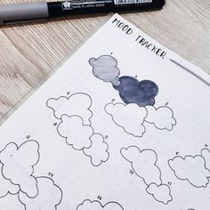 a notebook with some clouds on it and a marker next to it that says mood tracker