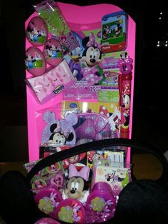 a minnie mouse bag is sitting on a table next to a pink box with various items in it