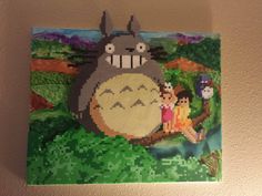 an image of the cartoon totoro on a wall with people standing next to it