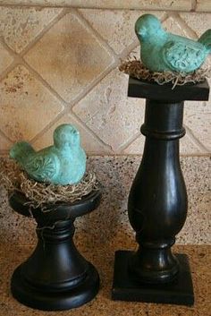 two birds sitting on top of black pedestals