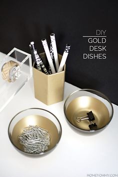 a white table topped with two bowls filled with pens and pencils