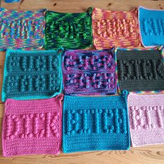 the crocheted squares are all different colors and have words written on each side