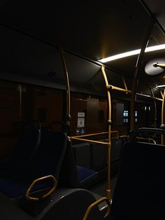 the interior of a public transit bus with blue seats and yellow railings at night