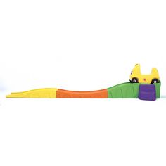 a toy truck is sitting on top of a plastic alligator's tail, with an orange and green car in the background