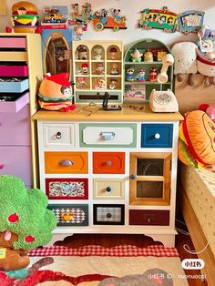 a toy kitchen with lots of toys on top of the cabinets and drawers in front of it