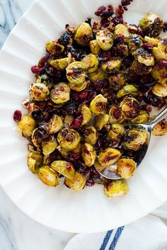 a white plate topped with brussel sprouts and cranberries