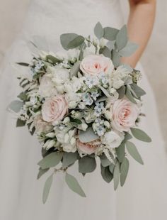 a bridal holding a bouquet of flowers and greenery