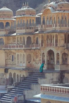 an old building with steps leading up to it and a person standing on the stairs