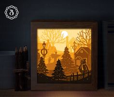 a shadow box with an image of a cat in the woods at night, on a shelf