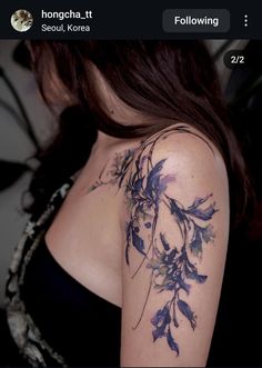 the back of a woman's shoulder with purple flowers on her left arm and chest