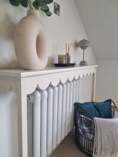 a white radiator next to a plant on top of a shelf in a room