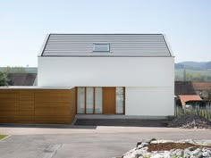 a white house with wooden shutters on the front and side doors open to let in light