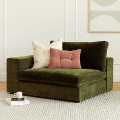 a green couch sitting on top of a white rug