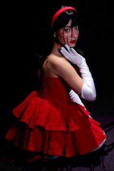 a woman dressed in red and white with blood on her face