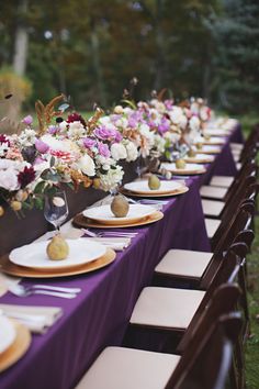 a long table with plates and flowers on it