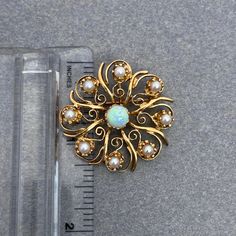 "This is a gorgeous mid-century rendition of a Victorian Sunburst pin. The 14k yellow gold is a bright yellow that sets off the bright white Cultured Pearl accents and Natural Opal center. The Opal has bright flashes of Blue and Green that plays well with the bright Cultured Pearl accents. The piece has a traditional hinged locking pin on the back, but also a hidden bail that makes it easy to wear as a pendant, a pearl enhancer OR you can use the hook to hang a locket or other pendant and wear i Heirloom White Brooch Jewelry, White Heirloom Brooch Jewelry, Art Deco Yellow Gold Jewelry With Screw Back, Formal Yellow Gold Starburst Jewelry, Elegant White Starburst Jewelry, Formal Gold Starburst Jewelry, Yellow Gold Round Brooch, Victorian Opal Yellow Gold Jewelry, Fine Jewelry Gold Brooches With Multi-stone