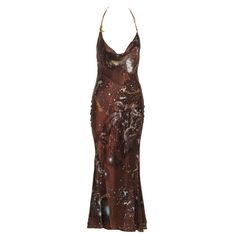 This Roberto Cavalli silk dress features a halter neckline with gold chain straps. The fabric showcases a rich brown base with intricate astrological-themed prints, including constellations, stars, and zodiac symbols. The cowl neckline drapes elegantly, while the fitted bodice and flared hem create a flattering silhouette. The backless design accentuates the sleek form, and the calf-length skirt offers a slightly flared finish. ▪ Brand: Roberto Cavalli ▪ Creative Director: Roberto Cavalli ▪ Collection: Fall-Winter 2003 ▪ Fabric: Silk ▪ Size: 'XS' ▪ Made in: Italy ▪ Condition: Very Good ▪ Mannequin: 183 cm / 6ft ---------------- Condition Grading Guidelines:  ▪ Pristine - No signs of wear with inclusion of original packaging ▪ Excellent - Very slight signs of wear with no visible flaws ▪ Ve Dress With Chain Straps, Roberto Cavalli Dress, Silk Halter Dress, Calf Length Skirts, Printed Silk Shirt, Rhinestone Dress, Maxi Knit Dress, Gianni Versace, Spice Girls