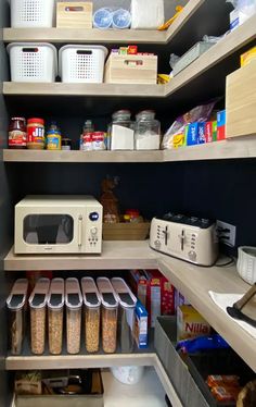 an organized pantry with lots of food and containers on the bottom shelf, along with other items