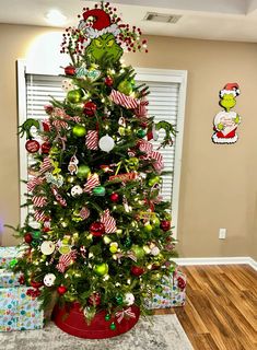 a christmas tree decorated with candy canes and ornaments in a red pot on the floor