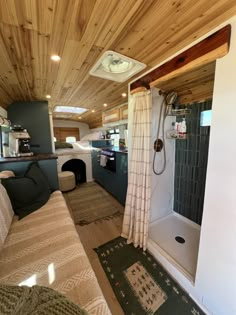 the interior of a camper with wood paneling on the ceiling and shower area