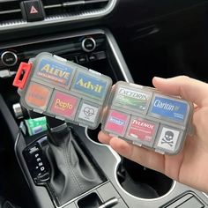 a person is holding an electronic device in their hand while they are on the car dashboard