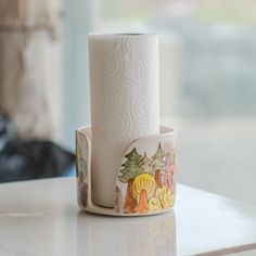 a roll of toilet paper sitting on top of a white counter next to a window