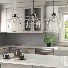 a kitchen with gray cabinets and white counter tops