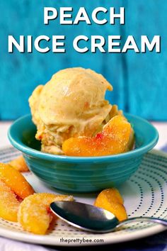 peach ice cream in a blue bowl on a plate with spoons next to it