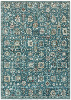 a blue rug with an ornate design on the top and bottom, in various colors