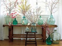 there are many vases with flowers in them on the table next to the window