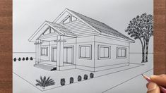 a drawing of a house with trees in the background and a person's hand pointing at it