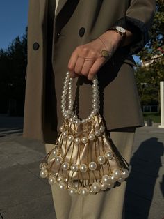 Elevate your style with our exquisite bridal clutch bag, crafted for both brides and guests attending special events. The luxurious mink color satin provides a sophisticated backdrop, complemented by large white pearls that encircle the bag, creating an opulent and timeless look. The handle, adorned with white pearls, adds a touch of glamour and refinement. Whether you're walking down the aisle or attending a special event, this clutch is designed to make a statement. The meticulous craftsmanship, coupled with the use of yellow threads, adds a subtle warmth, making it versatile for both daily and wedding occasions. Key Features: Luxurious mink color satin White pearl handle for a touch of elegance Large white pearls embellish the bag Versatile for daily and wedding events Meticulous crafts Bridal Bag For Wedding Day, Pearl Clutch Bag, Bridal Clutch Bag, Mink Colour, Pearl Clutch, Wedding Handbag, Bridal Bag, Bridal Clutch, Pearl Wedding